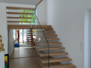 Glastragende Holztreppe Glasgeländer